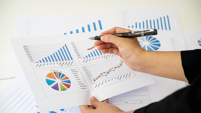 Cilvēks pēta datu tabulas un veic pierakstus