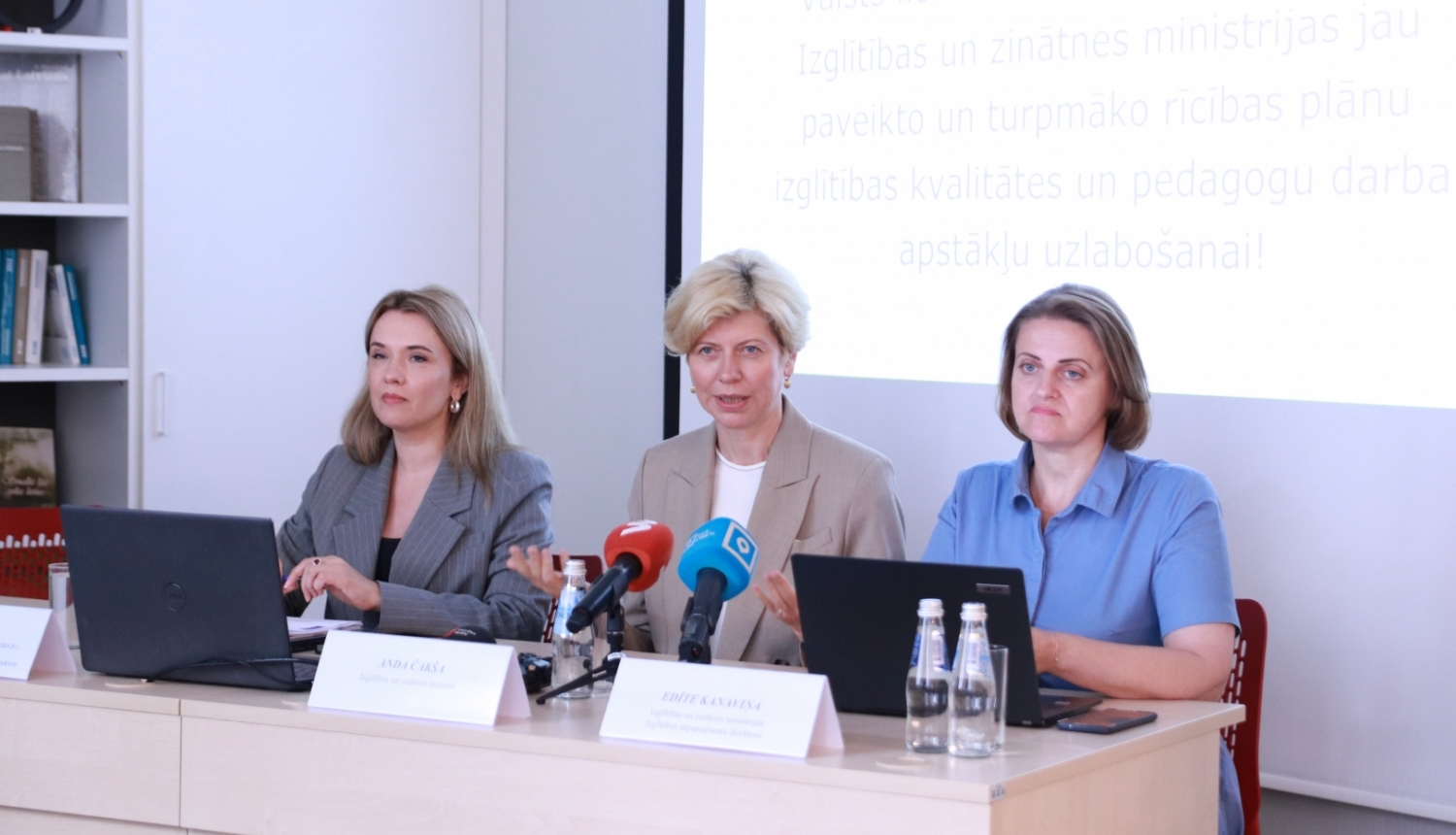 Ilze Saleniece, Anda Čakša un Edīta Kanaviņa sēž pie gada un runā. Uz galda mediju mikrofoni. 