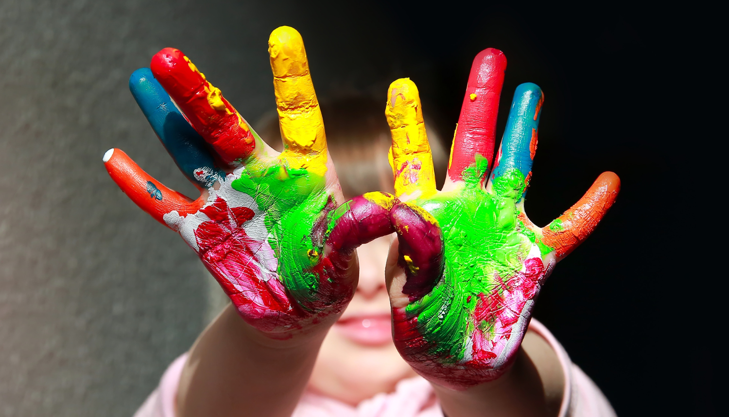 Bērna rokas, ar krāsām nokrāsotas plaukstas un pirksti 